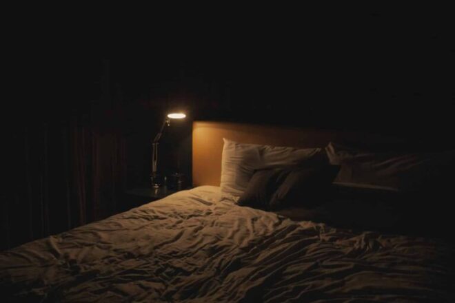 cama com uma lampada ligada