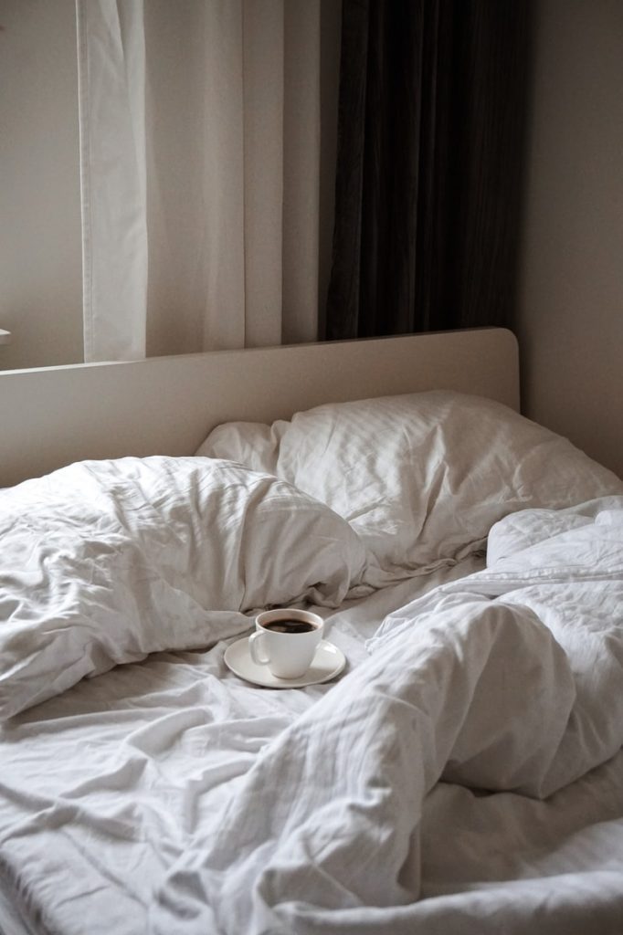 O que significa sonhar com Cama? Números e Tipos de sonhos 3 cama dessarumada com um copo de café
